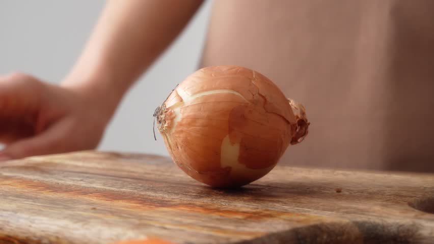 Peeling Onion Layers on Cutting Board. Close-up, shallow dof.