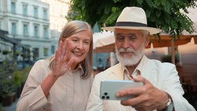 Happy grandparents blogging. Close up elderly couple retired family Caucasian woman man talk stream using gadget mobile phone talking travelling holidays online internet blog outside city street cafe - Powered by Shutterstock - Get 15% off with code: PIKWIZARD15