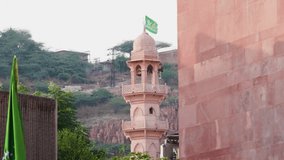 ancient mosque with waving religious flag at day from flat angle video is taken at ghantaGhar jodhpur rajasthan india.