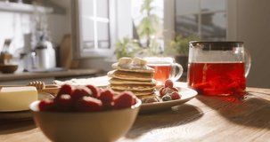 Pancake essence of American traditional breakfast. No people, advertising cinematic. Mouthwatering breakfast on warm wooden table, basked in gentle morning sunlight. Home cooking, individual approach