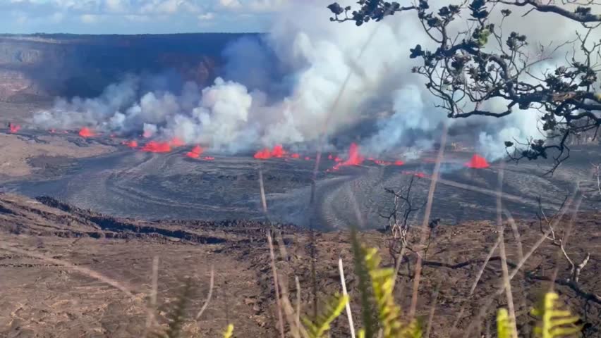 Cinematic long lens shot through foreground plants of Kilauea Volcano erupting in September 2023 on the Big Island of Hawai