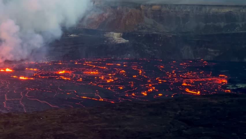 Cinematic long lens panning shot across the illuminated lava lake at Kilauea at sunset on the first evening of eruption in September 2023 at Hawai