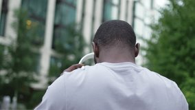 Music song concept. Good start day. Back view African American man listening modern hit walking on street in city. Unrecognizable person guy wearing headphones enjoy listening favorite music outdoor - Powered by Shutterstock - Get 15% off with code: PIKWIZARD15