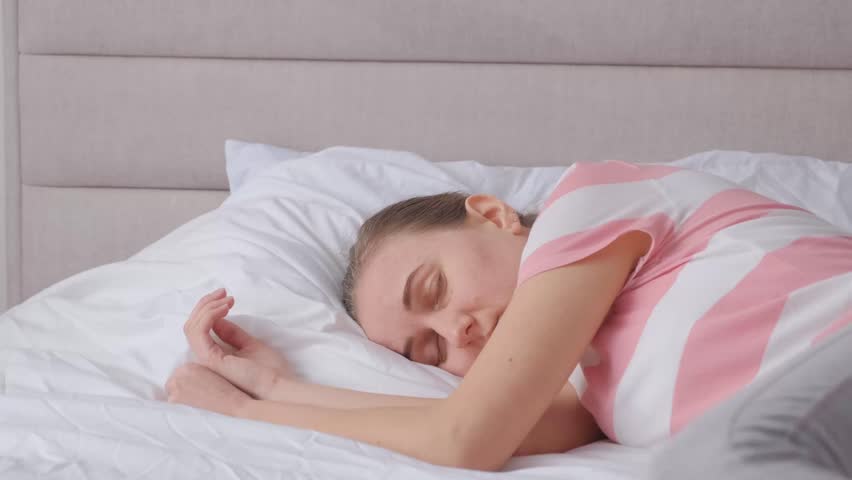 Upset depressed sick girl lying on bed in bedroom. Life crisis, insomnia, sleep disturbance.