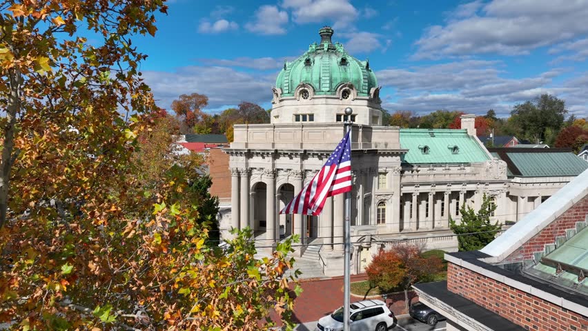 Old Town Winchester, Virginia. Handley Regional Library with American flag and autumn leaves. Aerial establishing shot of ornate building in small town America. - Powered by Shutterstock - Get 15% off with code: PIKWIZARD15