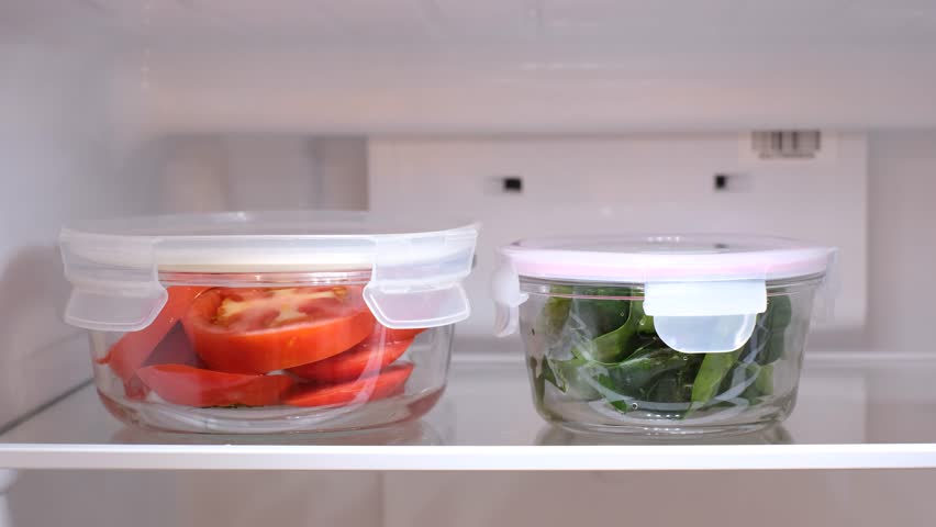 Female hands fold glass containers with vegetables into refrigerator, front view. Royalty-Free Stock Footage #1111268317