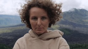 Emotional woman on mountain peak enjoys nature. Dynamic video montage of emotional woman in wilderness in windy weather, highlighting woman's connection with nature and freedom. Concept emotional life