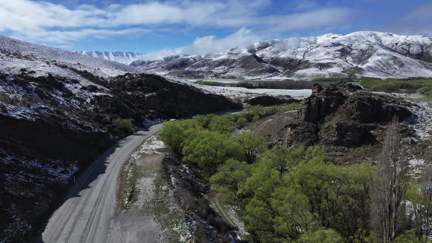 Scenic road to snow alpine Lindis pass in New Zealand. Winter aerial landscape, road trip.