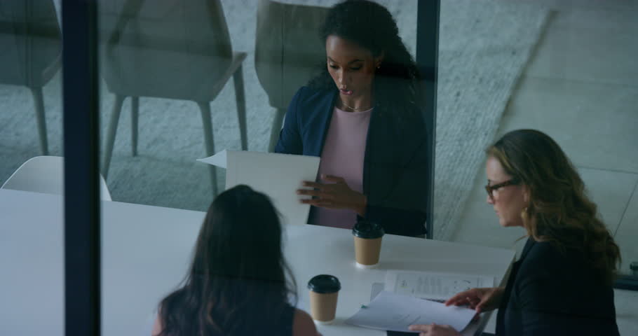 Start, documents or business women in meeting for discussion, sales report or data analysis. Group of people, team or manager speaking of paperwork, budget planning or audit portfolio late in office