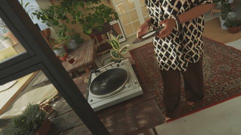 Young black relaxed woman dancing to vinyl record player while spending time at home garden Arkivvideo