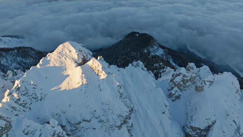 Aerial reveal of the snow-covered Peitlerkofel and Gardertal (Val Badia) in South Tyrol, Italy, showcasing a stunning winter landscape.