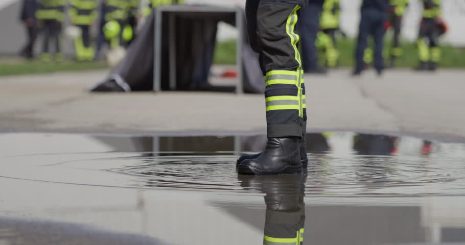 A professional firefighter is seen diligently cleaning and storing fire hoses after a hazardous operation, exemplifying the importance of post-operation maintenance and safety protocols in the Royalty-Free Stock Footage #1111293073