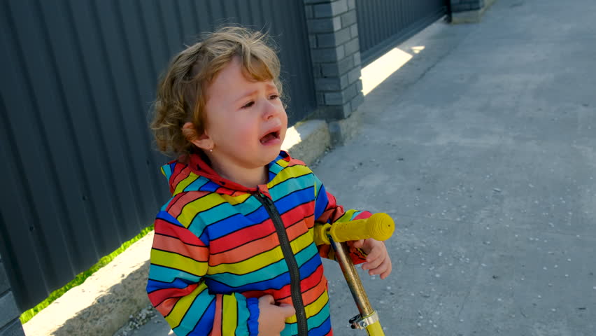 A child is crying on the street. Selective focus.