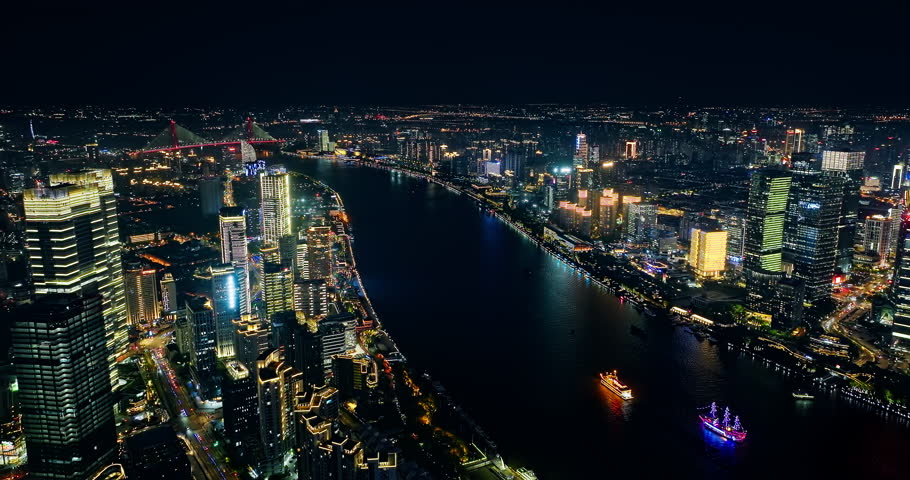 Aerial view of Huangpu River and modern buildings at night in Shanghai, China.