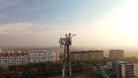 A mobile operator's communication tower on the outskirts of the city. View of the communication tower with antennas from a drone. Aerial photography of telecommunication equipment.