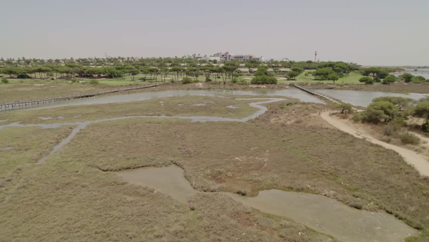 Marshes and high tide at midday. Wooden walkways. Aerial view flying over the marshes. Andalusia. Spain.