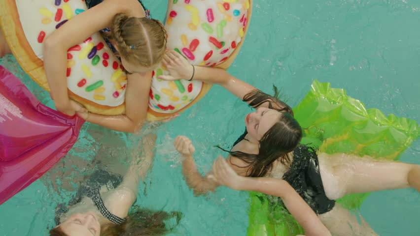 Overhead view of girls swimming and playing in swimming pool - vertical video, cedar hills, utah, united states Royalty-Free Stock Footage #1111300539