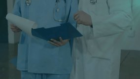 Animation of flowchart of icons over caucasian doctors discussing patient reports in hospital. Digital composite, multiple exposure, communication, teamwork, medical and technology concept. - Powered by Shutterstock - Get 15% off with code: PIKWIZARD15