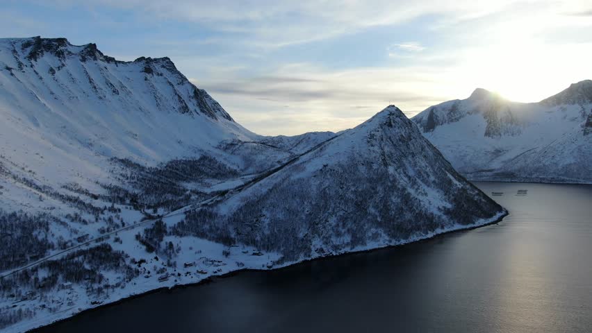 Drone view on the Tromso mountains in winter full of snow showing norwegian mountains next to the sea in Norway