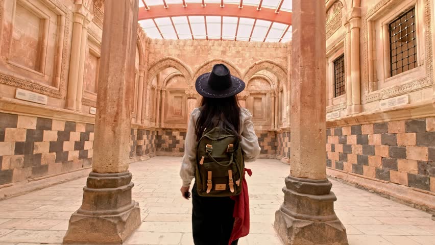 Tourist woman visiting the historical Ishak Pasha Palace in Ağrı.A traveling photographer explores historical places and photographs the environment.Image of the girl walking in the historical palace
