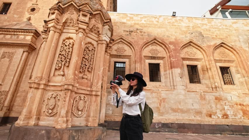Photographer tourist woman visiting the historical Ishak Pasha Palace in Turkey’s Ağrı province is shooting a vlog with her camera for her followers. Visiting historical places.