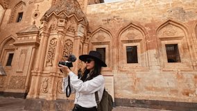 Photographer tourist woman visiting the historical Ishak Pasha Palace in Turkey’s Ağrı province is shooting a vlog with her camera for her followers. Visiting historical places.