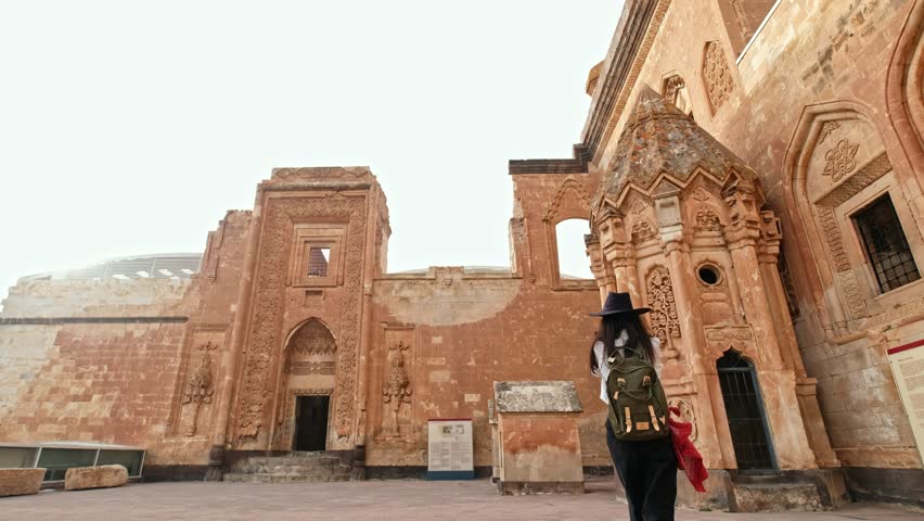 Tourist woman visiting the historical Ishak Pasha Palace in Ağrı.A traveling photographer explores historical places and photographs the environment.Image of the girl walking in the historical palace