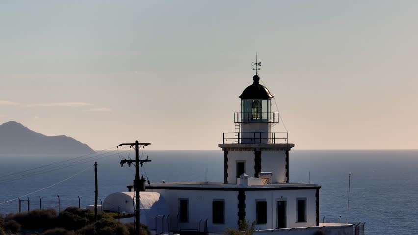 Drone view of lighthouse in Santorini in Greece, an island in the Cyclades. View of the magnificent white houses of Fira and Oia | Shutterstock HD Video #1111307391