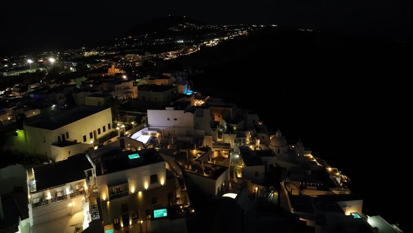 Night drone view of Santorini in Greece, an island in the Cyclades. View of the magnificent white houses of Fira and Oia | Shutterstock HD Video #1111307461