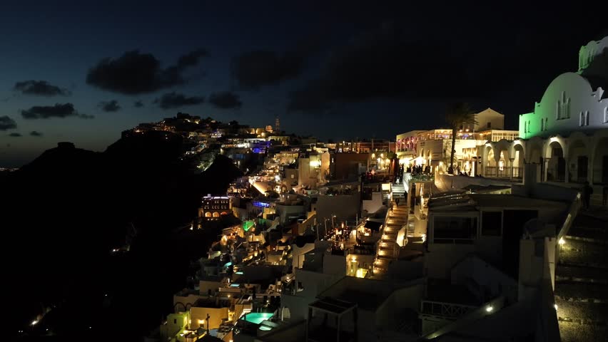 Night drone view of Santorini in Greece, an island in the Cyclades. View of the magnificent white houses of Fira and Oia | Shutterstock HD Video #1111307463