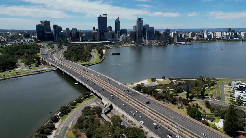 Cinematic aerial view of Narrows Bridge freeway on Swan River with the view of Perth City famous skyline buildings in the background, Perth, Western Australia