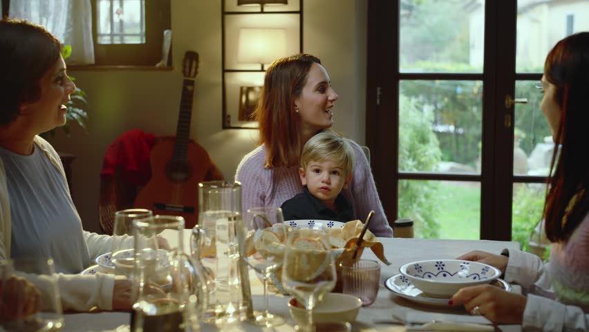 A beautiful family sitting at the dining table, talking, laughing and joking.
A young boy brings pasta, a typical Italian dish, to the table. Royalty-Free Stock Footage #1111310617