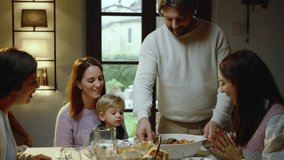 A beautiful family sitting at the dining table, talking, laughing and joking.
A young boy brings pasta, a typical Italian dish, to the table. - Powered by Shutterstock - Get 15% off with code: PIKWIZARD15