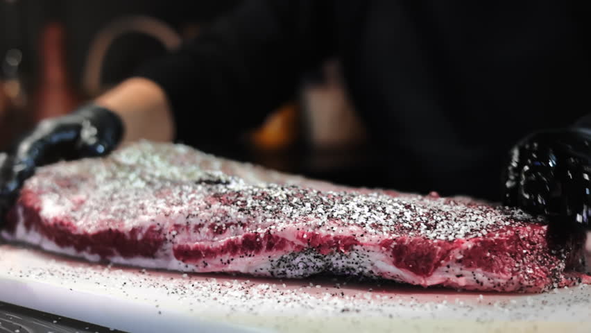Male chef hands adding seasonings herbs salt cooking farm meat steak on marble board at restaurant closeup slowmo. Man cookery in black gloves rub dry fragrance aroma condiment to pork beef for bbq Royalty-Free Stock Footage #1111311297