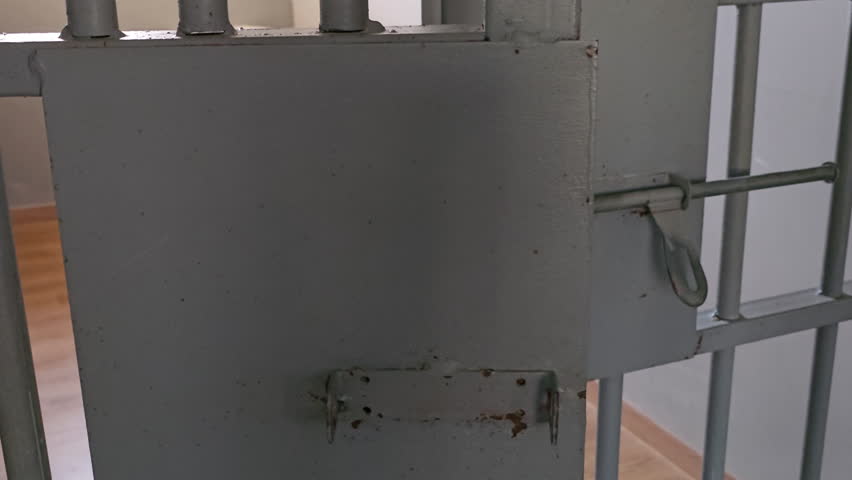 Man Hands Lock Latch Slide Barrel to Close Prison Cell Door - closeup Royalty-Free Stock Footage #1111312077