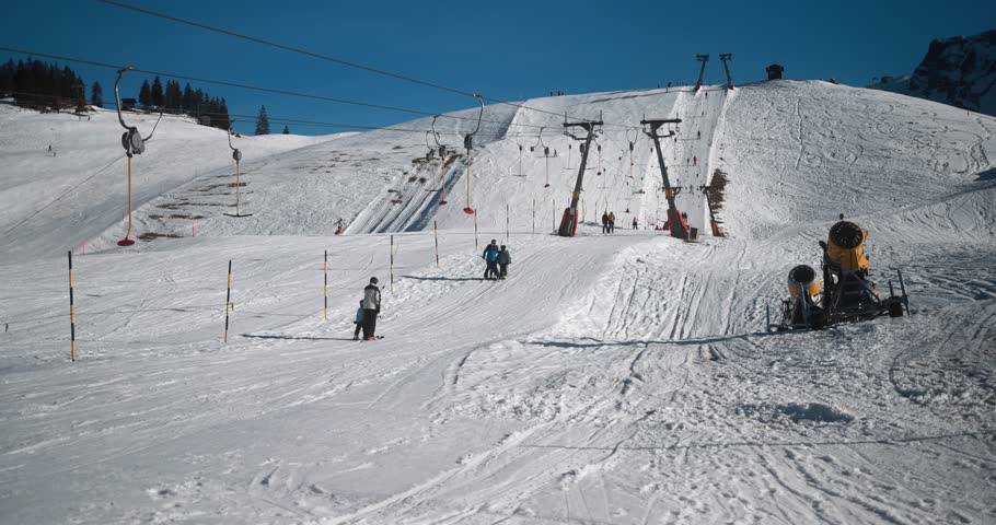 People skiing in alps mountains winter resort on sunny day - Skier riding down on taking ski lift for going up - Snow sport training and vacation concept  Royalty-Free Stock Footage #1111313159