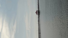 Vertical 4k video of long red bridge over ocean in Thailand.