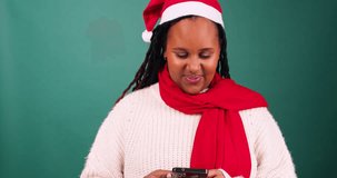 Young woman looks to camera and smiles, texting friends over Christmas, studio