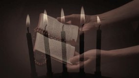 Composite video of burning candles against woman hands holding bible and rosary praying. Christianity and religion concept