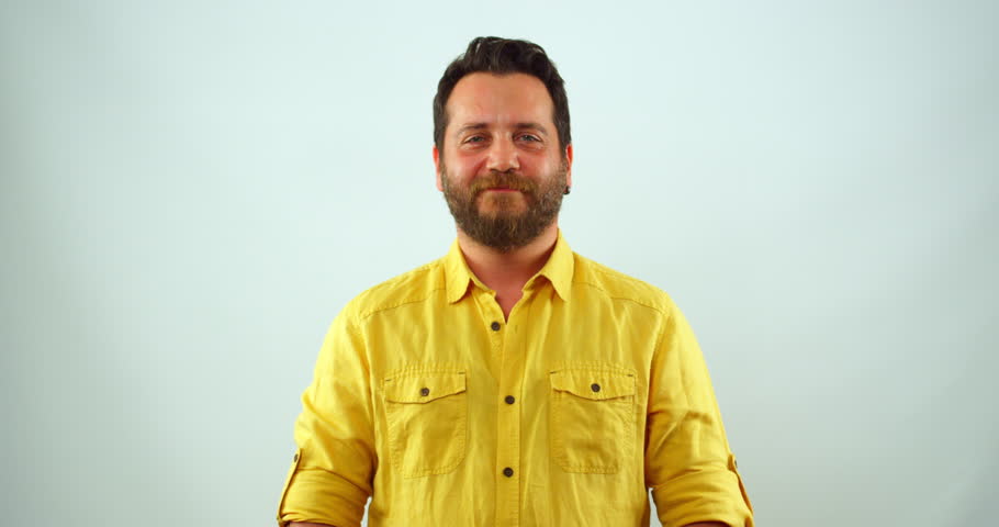 A middle-aged blonde man looks at the camera and smiles in slow motion