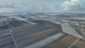Bird eye 4k video in winter. Drone flying above the agriculture field covered with snow