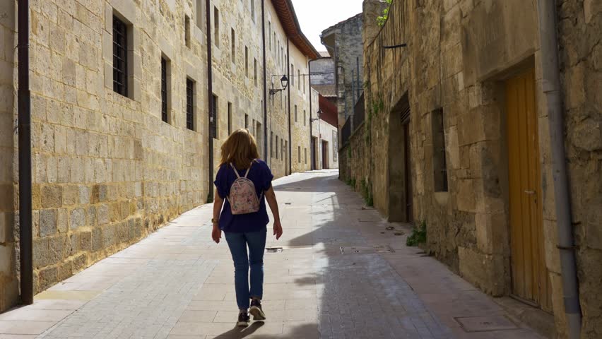Female tourist strolling through the streets of the Basque village of Salvatierra in northern Spain.