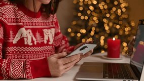 Christmas online shopping, sales and discounts promotions during winter holidays, online shopping at home. Female hands on the phone and laptop with credit card and blurred bokeh lights - Powered by Shutterstock - Get 15% off with code: PIKWIZARD15