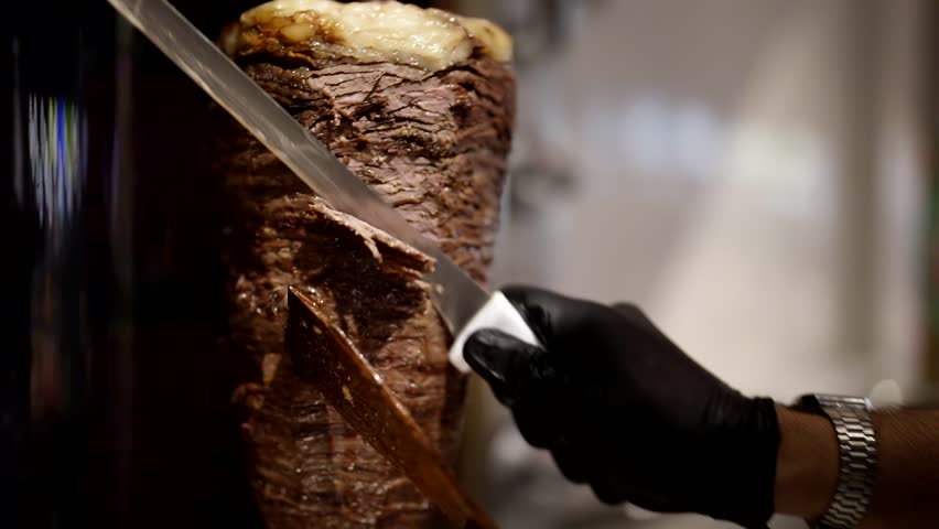 Cook slicing meat for shawarma cooking, closeup view, national Turkish street food | Shutterstock HD Video #1111365389
