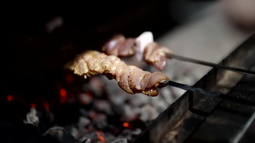 Cooking meat on skewers above hot coals, traditional Caucasus meal shashlik, closeup view | Shutterstock HD Video #1111365545