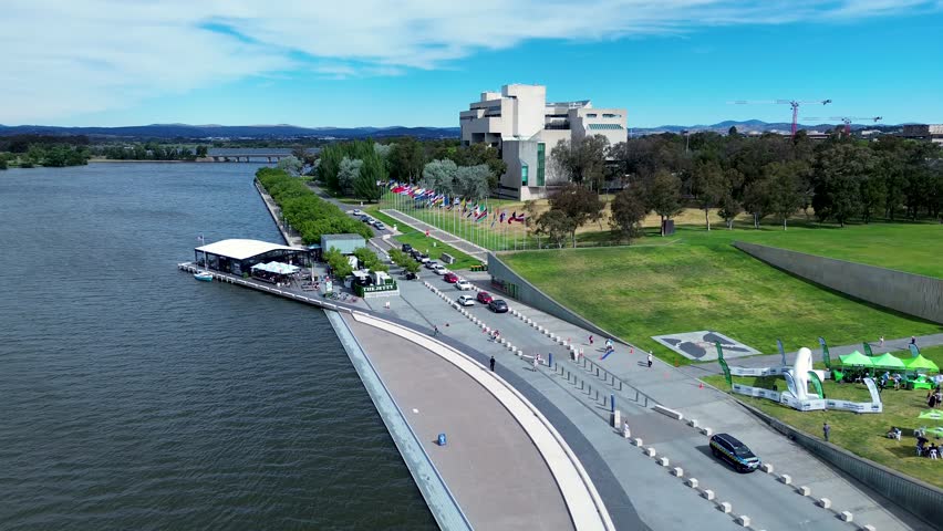 Drone aerial shot National art gallery The Jetty international flags boardwalk foreshore park Lake Burley Griffin Parliamentary zone Canberra travel tourism ACT Australia 4K Royalty-Free Stock Footage #1111368307