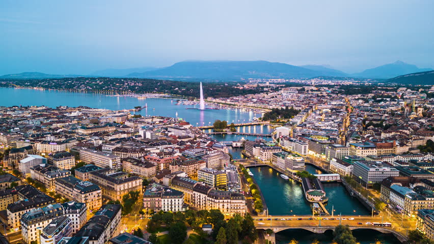 Geneva, Switzerland skyline view towards the Jet d'Eau fountain in Lake Geneva at twilight.