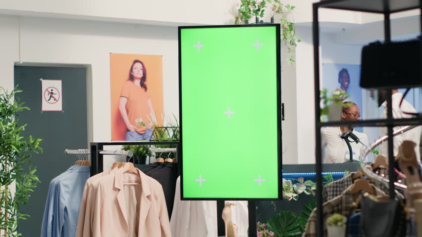 Green screen kiosk in luxury clothing shop advertising new collection of elegant formalwear clothes. Chroma key mockup digital display in fashion boutique used to promote store garments