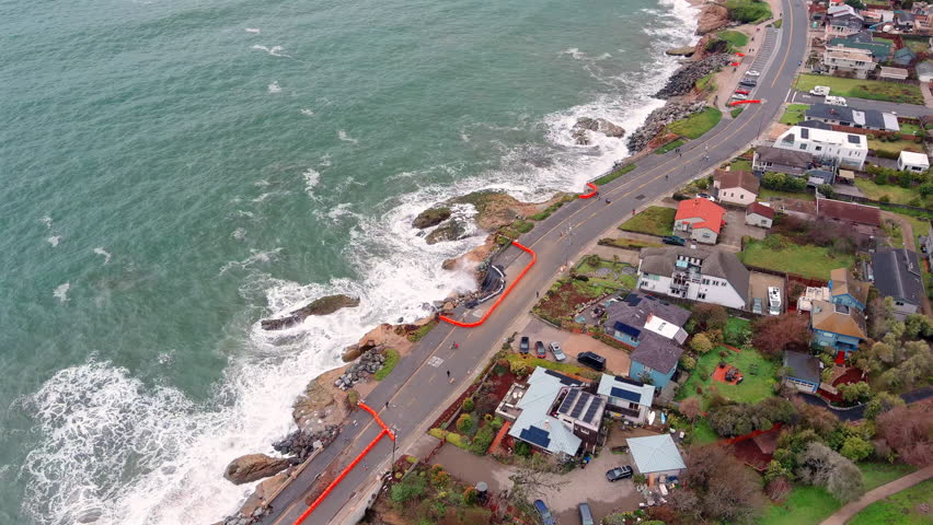 Downward aerial view of storm-hit ocean walkway, ongoing roadwork. Santa Cruz, California