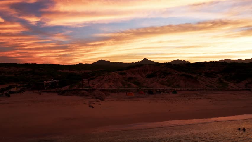 Fire red sunset illuminates briliant sky, silhouette of mountains near Cabo Pulmo below Royalty-Free Stock Footage #1111373769